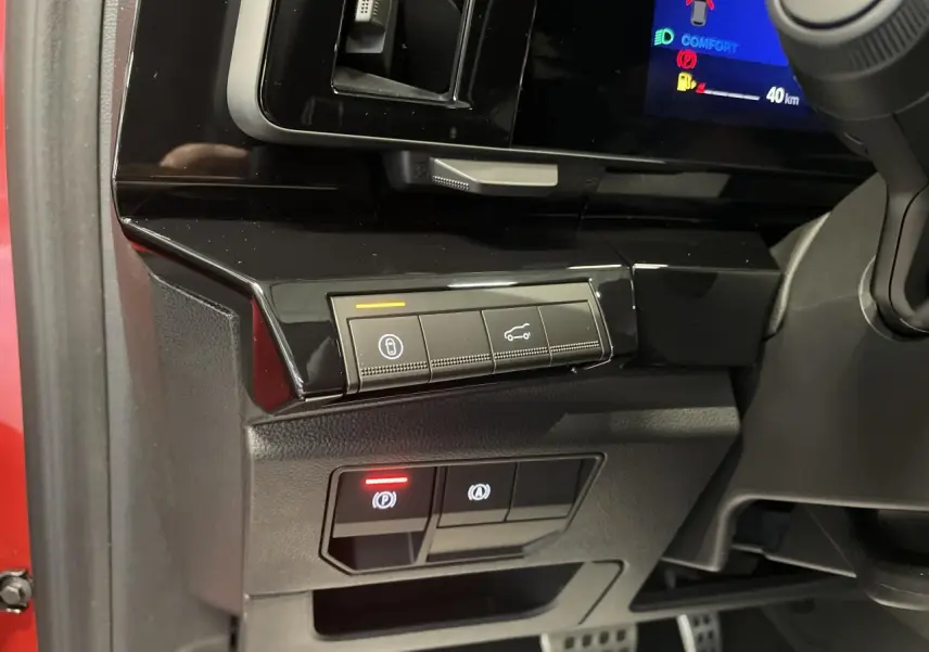 Vue intérieure côté conducteur du tableau de bord noir brillant et commandes électroniques du Renault Austral 2025 rouge métallisé.