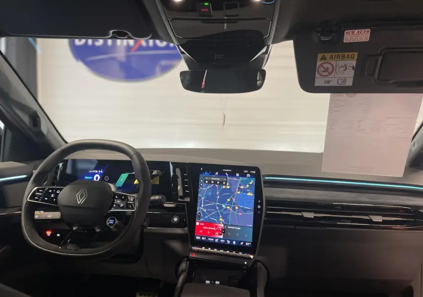 Vue intérieure avant du Renault Austral 2025 avec tableau de bord numérique et écran tactile central vertical.