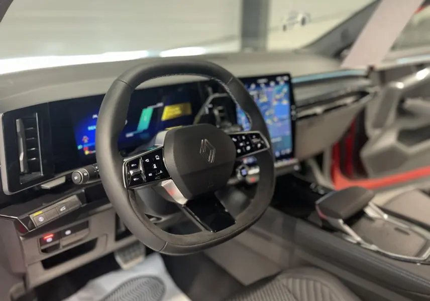 Vue intérieure du volant et tableau de bord numérique du Renault Austral 2025 avec finitions noires et écrans tactiles lumineux.