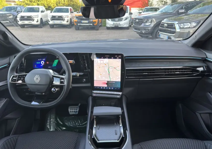 Vue intérieure avant du Renault Austral New 200 Esprit Alpine, tableau de bord noir avec écran tactile vertical et volant multifonctions.