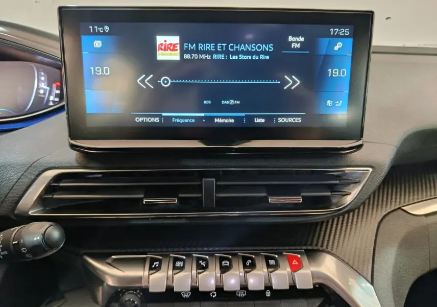Vue rapprochée du tableau de bord du Peugeot 5008 gris clair 2023, avec écran tactile central et commandes piano.