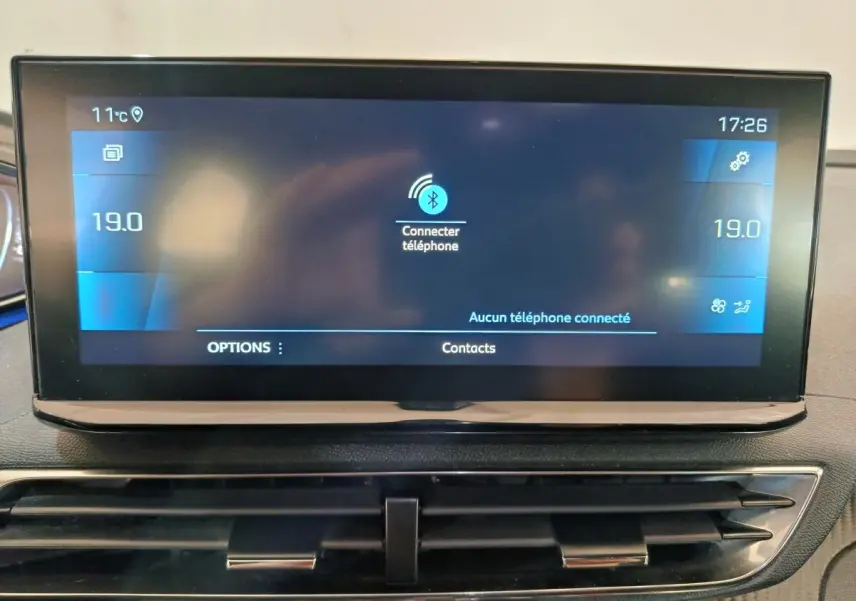 Écran tactile central du tableau de bord du Peugeot 5008 gris clair, affichant la connexion Bluetooth et la température à 19°C.