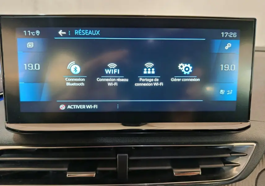 Écran tactile central du tableau de bord du Peugeot 5008 gris clair affichant les options de connexion Wi-Fi et Bluetooth.