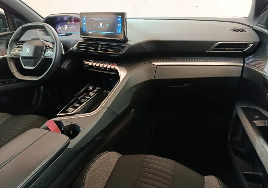 Intérieur avant droit du Peugeot 5008 gris clair 2023, volant cuir multifonctions et écran tactile central visible.