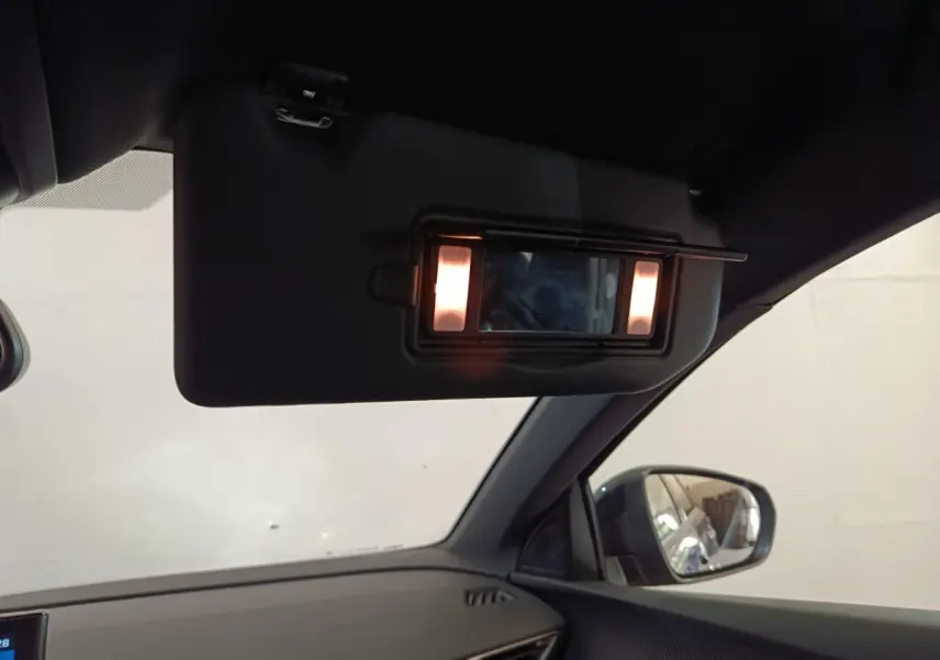 Détail intérieur du pare-soleil avec miroir éclairé côté droit dans un Peugeot 5008 gris clair 2023.