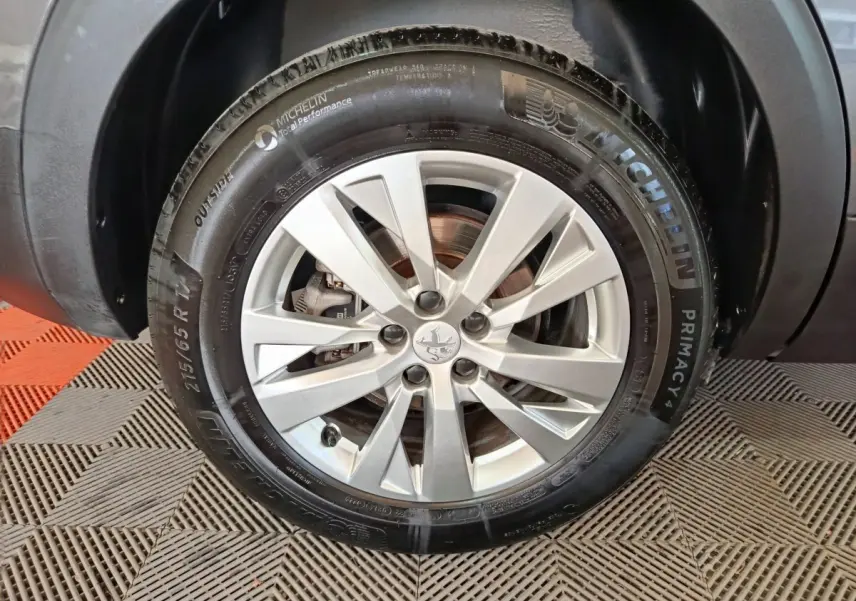Gros plan sur la roue avant droite du Peugeot 5008 gris clair, avec jante alliage et pneu Michelin Primacy 4.