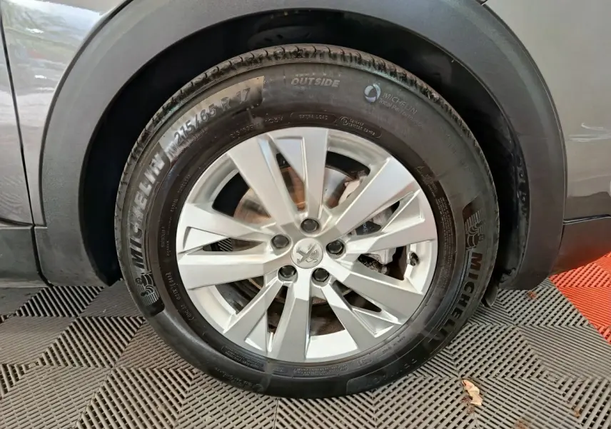 Gros plan sur la roue avant droite gris clair du Peugeot 5008 avec jante alliage et pneu Michelin.