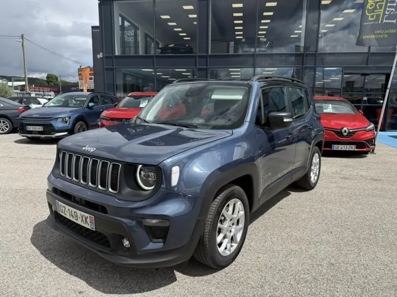 Jeep Renegade bleu métal en vue 3/4 avant droit, avec calandre distinctive à sept fentes et jantes argentées.