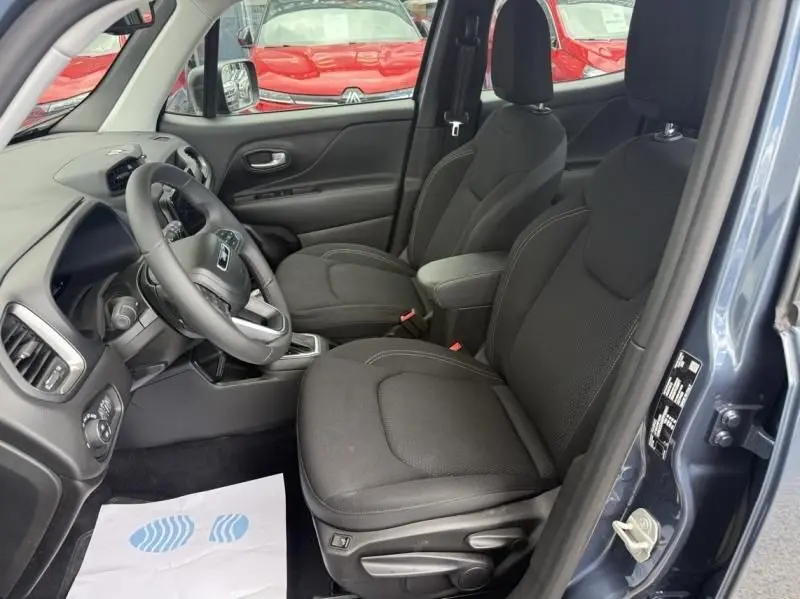 Vue intérieure côté gauche du Jeep Renegade 2024 bleu métal, montrant les sièges avant noirs et le volant.