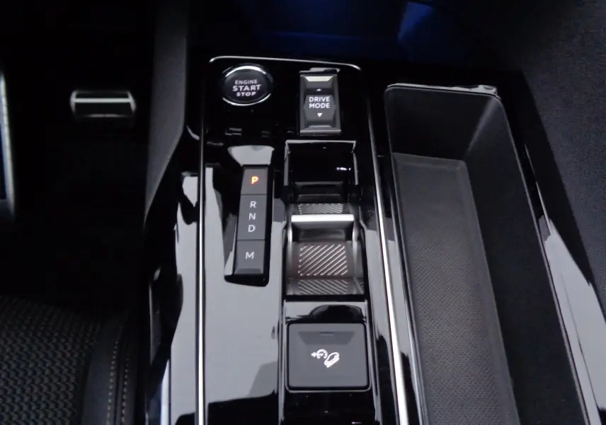 Console centrale brillante avec levier de vitesses automatique et bouton drive mode dans un Peugeot 3008 gris 2023.