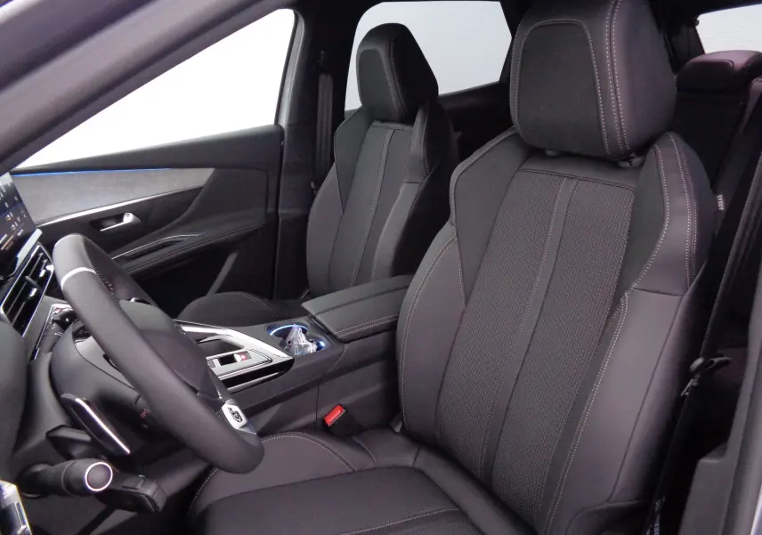 Intérieur du Peugeot 3008 2023, vue côté conducteur, sièges en cuir noir avec surpiqûres contrastées et volant sport.