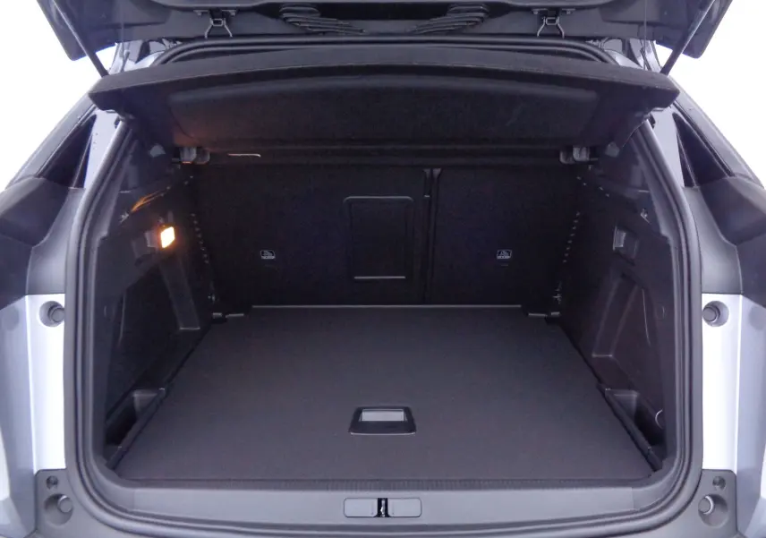Coffre ouvert du Peugeot 3008 gris Artense métal, vue arrière montrant un espace de chargement spacieux et bien fini.