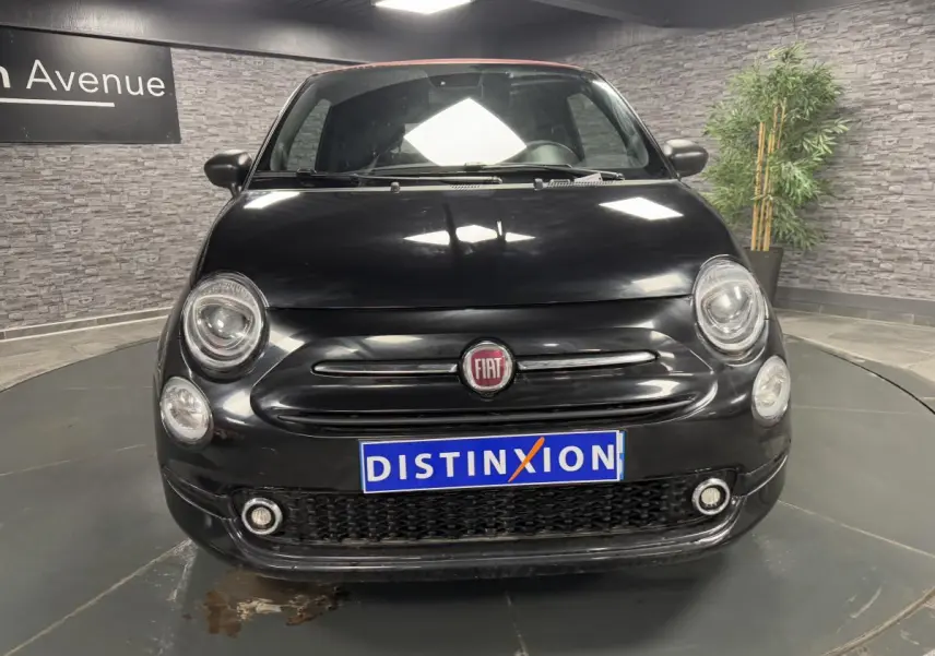 Vue frontale d'une Fiat 500 Cabriolet noire avec capote rouge et logo FIAT visible sur la calandre.