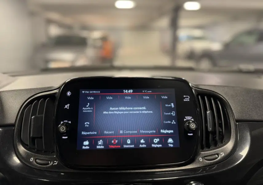 Écran tactile central allumé du tableau de bord noir de la Fiat 500 Cabriolet 2024 avec commandes multimédia visibles.