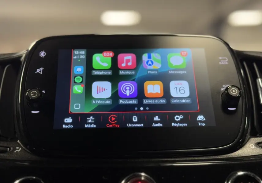 Écran tactile central du tableau de bord de la Fiat 500 Cabriolet 2024, affichant Apple CarPlay en fonctionnement.