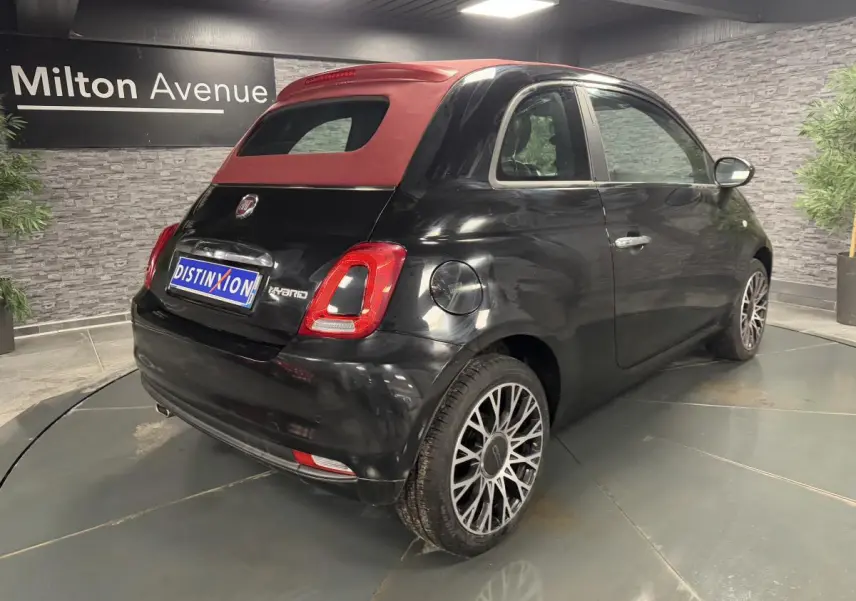 Vue 3/4 arrière droite d'une Fiat 500 noire avec capote rouge et jantes alliage 16 pouces Spider.