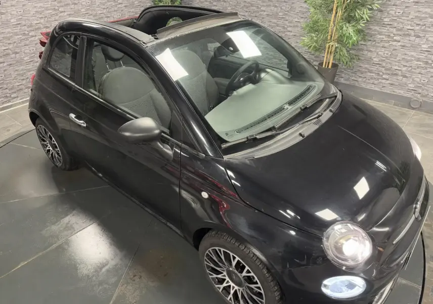 Fiat 500 Cabriolet noire vue 3/4 avant droit avec capote ouverte et jantes alliage 16 pouces Spider.