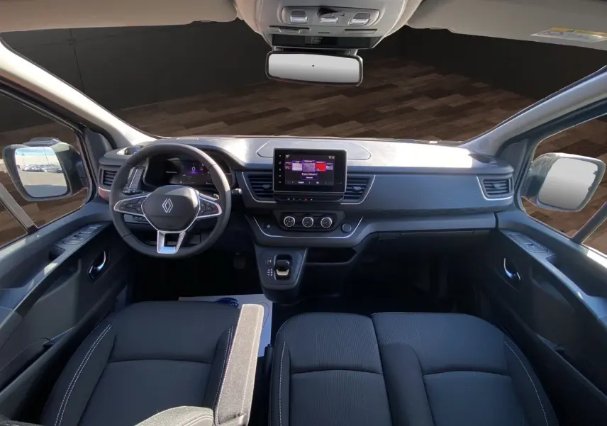 Intérieur noir du Renault Trafic Combi 2025 vu de face, tableau de bord moderne avec écran tactile central.