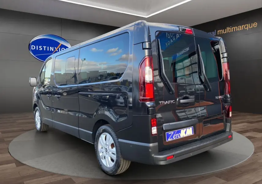 Vue 3/4 arrière droite du Renault Trafic Combi noir 2025 avec portes vitrées et jantes alliage 17 pouces.