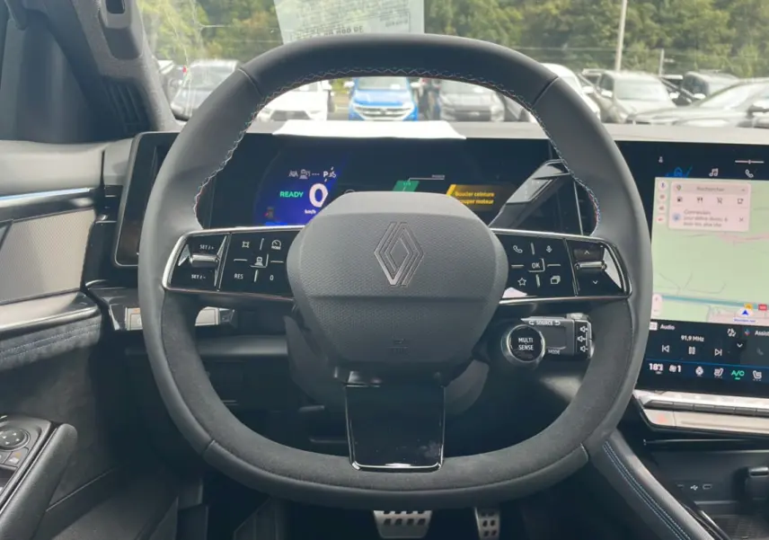 Vue intérieure centrée sur le volant en alcantara noir du Renault Austral New 200 Esprit Alpine avec tableau de bord digital.