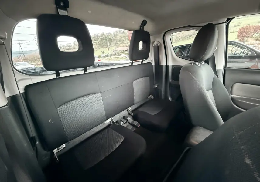 Vue intérieure arrière du Mitsubishi L200 Club Cab 2017, sièges noirs en tissu avec appuie-têtes ajourés.