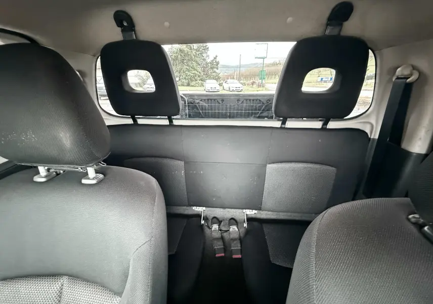 Vue intérieure arrière du Mitsubishi L200 Club Cab 2017, sièges noirs et banquette arrière compacte visible.