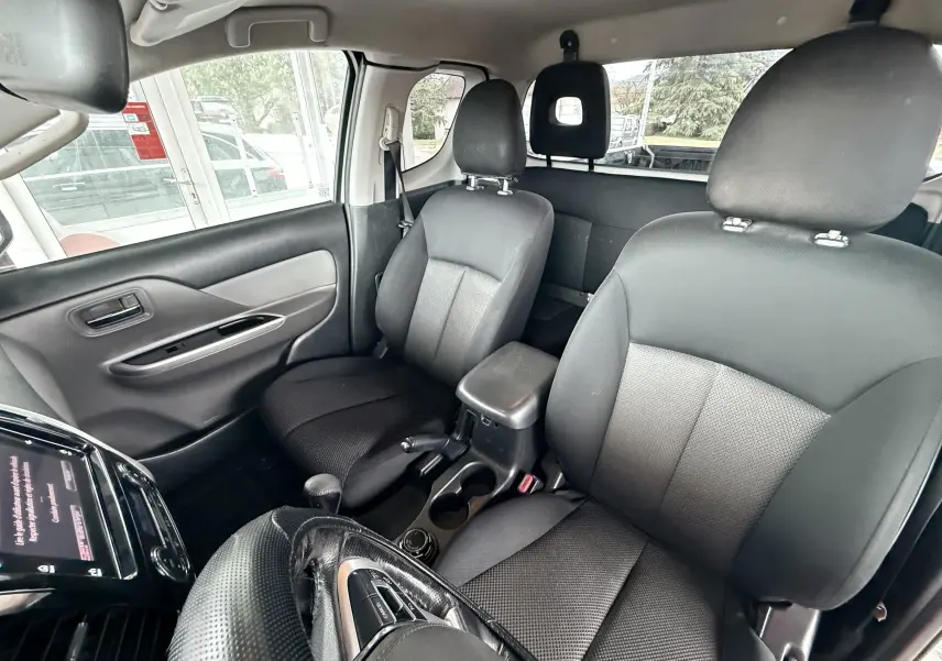 Vue intérieure du Mitsubishi L200 Club Cab 2017 montrant les sièges avant noirs et la console centrale entre eux.