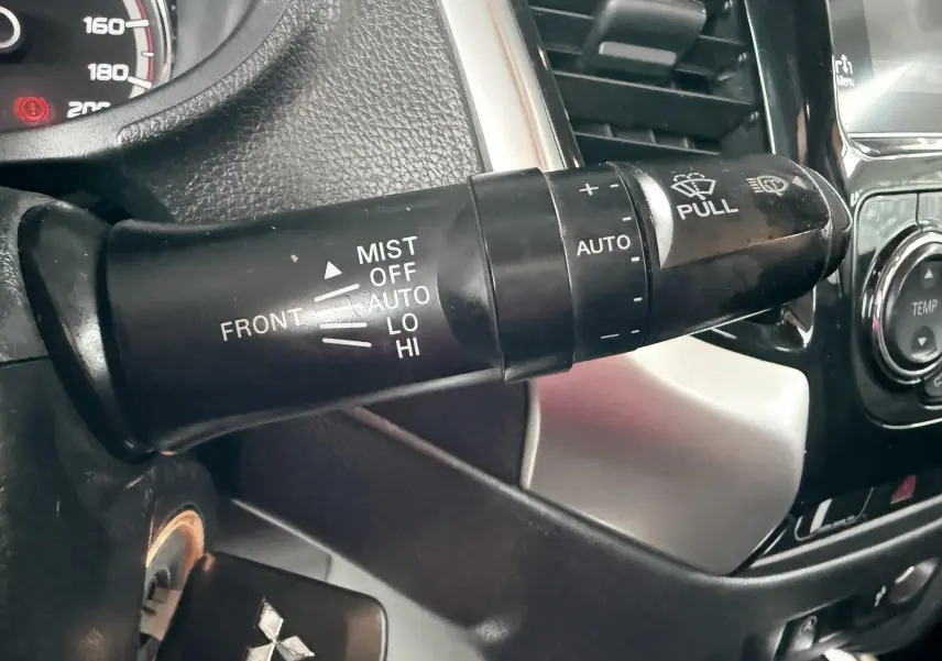 Gros plan sur la manette d’essuie-glace côté gauche du tableau de bord du Mitsubishi L200 blanc 2017.