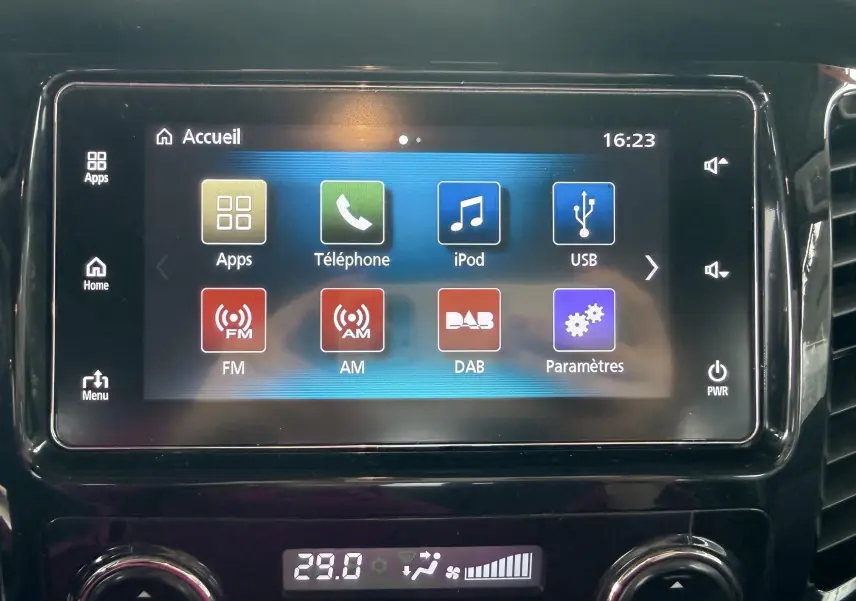 Écran tactile central du Mitsubishi L200 blanc, affichant le menu principal avec options multimédia et réglages.