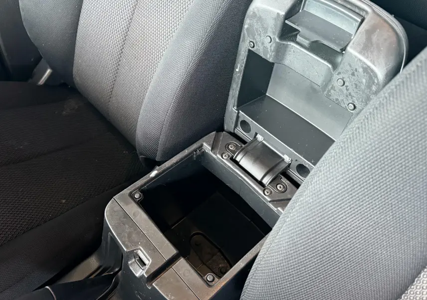 Vue rapprochée de la console centrale ouverte entre les sièges noirs du Mitsubishi L200 Club Cab 2017.