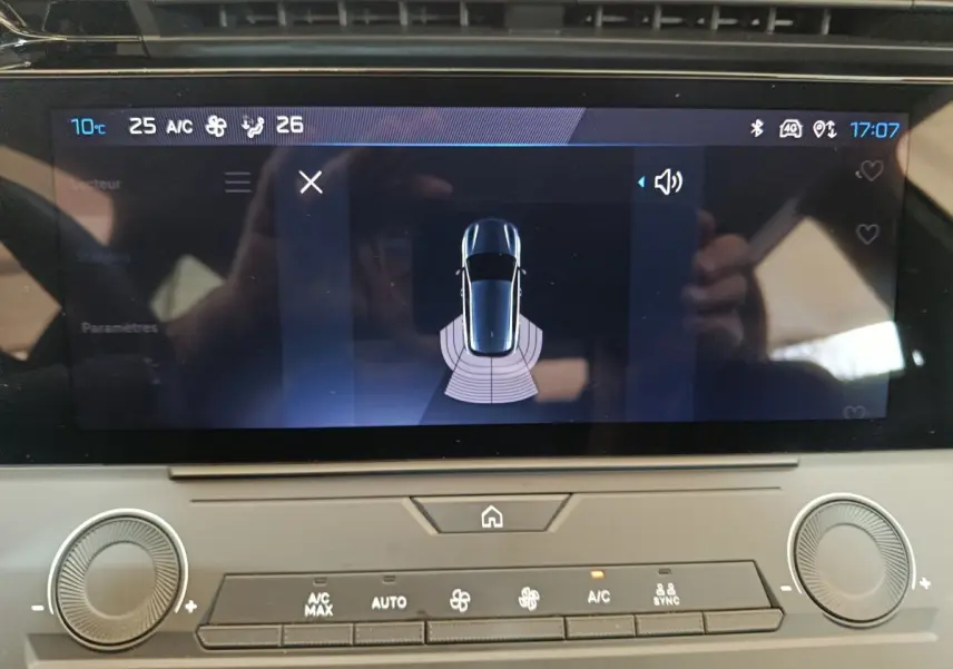 Écran tactile central de la Peugeot 308 blanc 2022 affichant l’aide au stationnement et commandes climatisation.