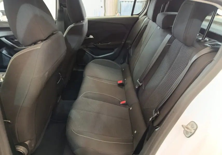Vue intérieure côté droit des sièges arrière noirs d'une Peugeot 308 blanche, avec ceintures et appuie-têtes visibles.