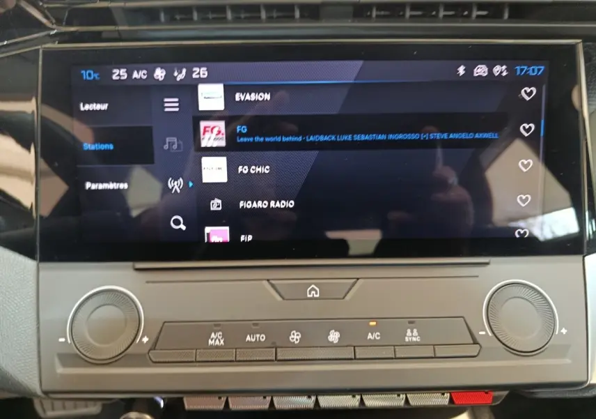 Écran tactile central affichant les stations radio dans l’habitacle d’une Peugeot 308 blanche, vue de face.
