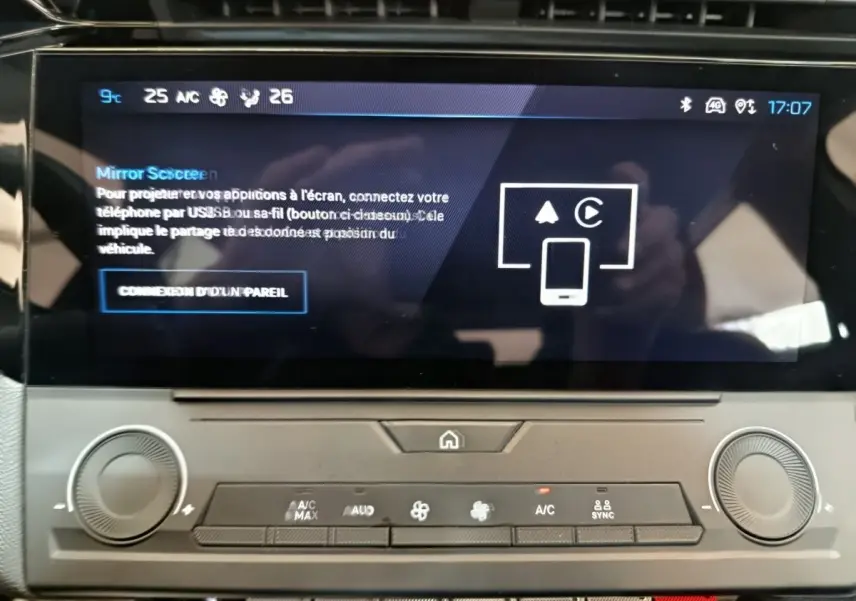 Vue rapprochée de l’écran tactile central et des commandes de climatisation d’une Peugeot 308 blanche de 2022.