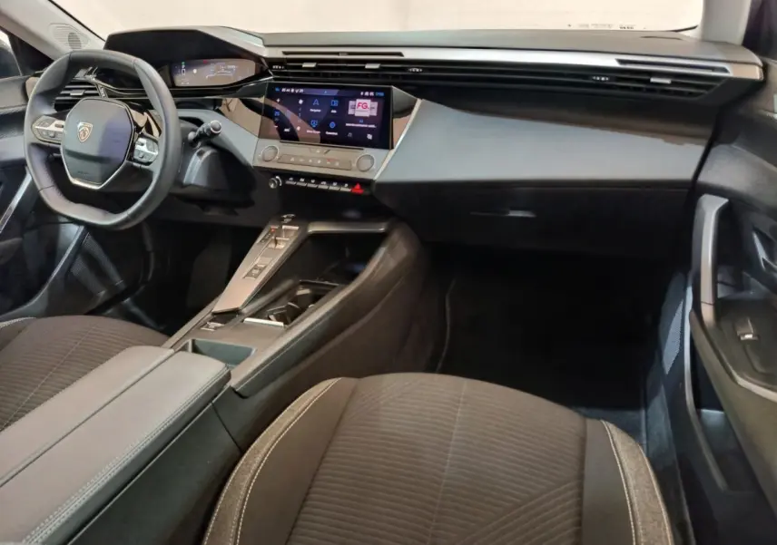 Vue intérieure avant droite de la Peugeot 308 2022 avec tableau de bord digital et volant cuir multifonctions.