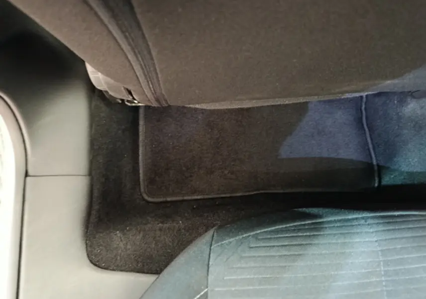 Vue rapprochée du sol et tapis noir côté passager arrière de la Peugeot 308 blanche 2022 Active Pack.