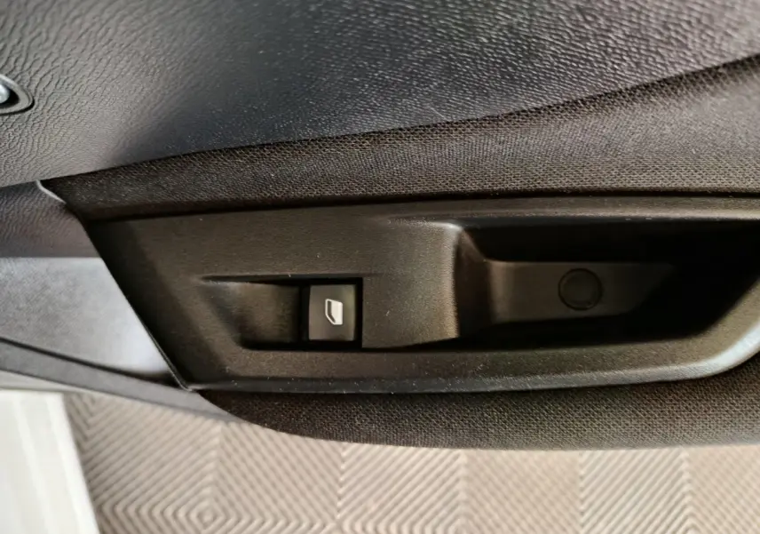 Gros plan sur le bouton de commande de ventilation additionnelle côté passager dans une Peugeot 308 blanche.