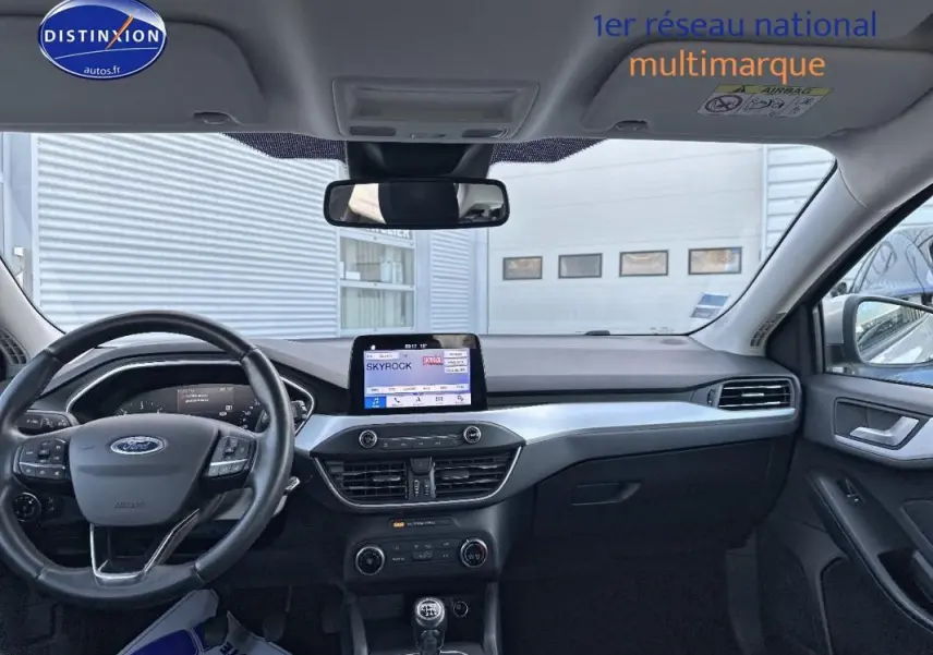 Intérieur avant de la Ford Focus gris clair 2019, tableau de bord avec écran tactile et volant multifonction.