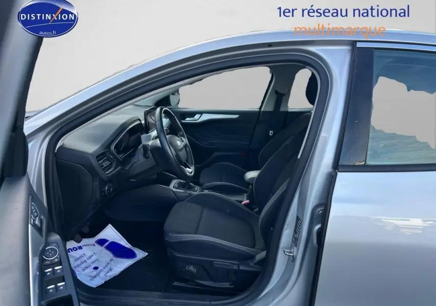 Vue côté gauche intérieur d'une Ford Focus gris clair 2019, montrant sièges avant et tableau de bord moderne.