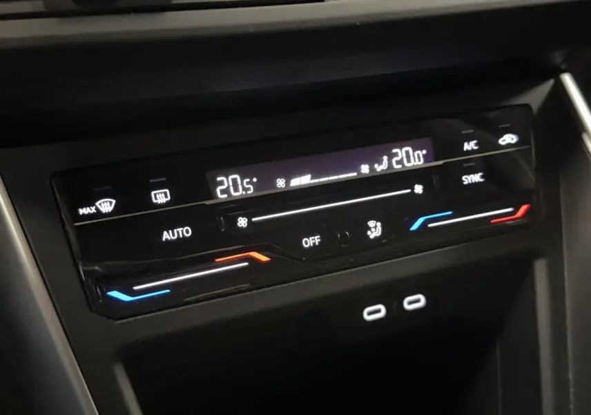 Gros plan sur la commande de climatisation digitale du Volkswagen Taigo gris, avec affichage température et deux ports USB-C.