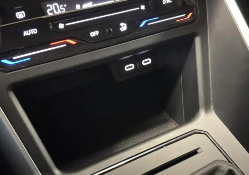Vue rapprochée de la console centrale noire du Volkswagen Taigo 2024 avec deux ports USB-C et commandes de climatisation.