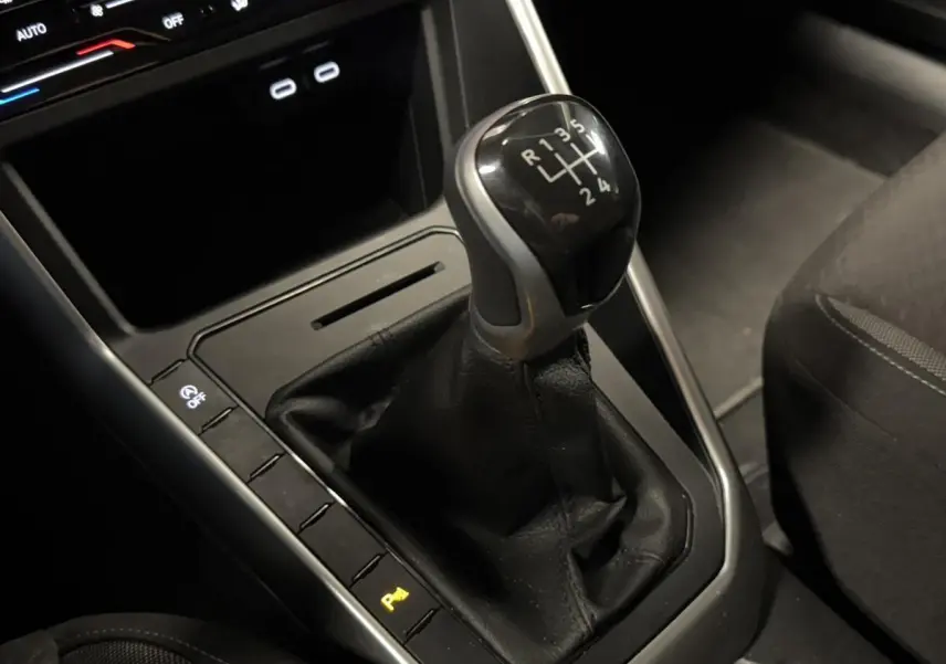 Le levier de vitesses manuel noir du Volkswagen Taigo 1.0 TSI 95 Life vu en gros plan côté droit intérieur.