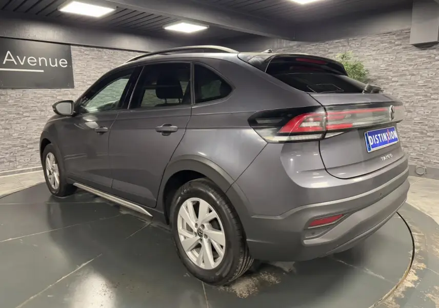 Volkswagen Taigo gris en 3/4 arrière droit, avec jantes alliage Belmopan et feux arrière LED allumés.