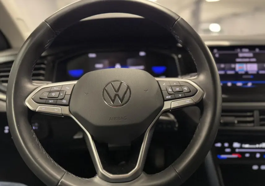 Volant cuir multifonctions Volkswagen Taigo 2024 vu de face avec tableau de bord numérique et écran tactile.