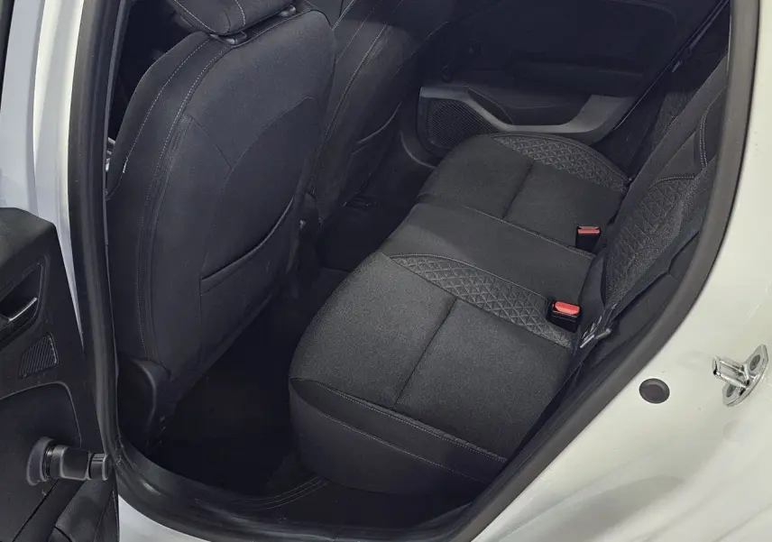 Vue côté gauche arrière de la Renault Clio blanche glacier 2020, montrant les sièges arrière en tissu gris noir.