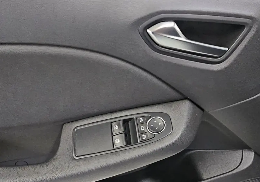 Détail de la porte côté conducteur de la Renault Clio 2020 avec commandes de vitres et rétroviseurs noirs.