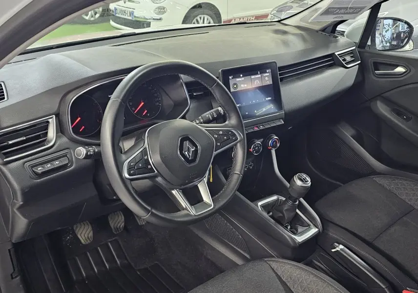 Intérieur avant droit de la Renault Clio 2020 blanc glacier, volant multifonction et boîte manuelle visibles.