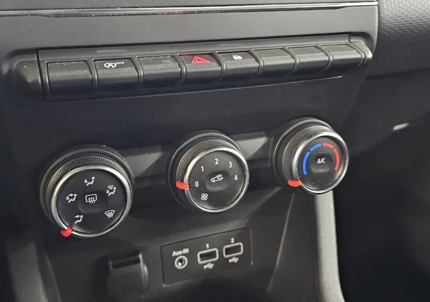 Gros plan sur les commandes de climatisation et connectiques USB de la Renault Clio blanche Glacier 2020.