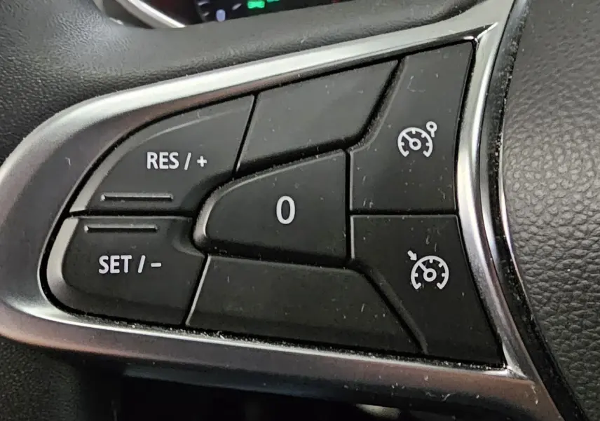 Gros plan sur les commandes de régulateur de vitesse au volant d'une Renault Clio blanche Glacier de 2020.