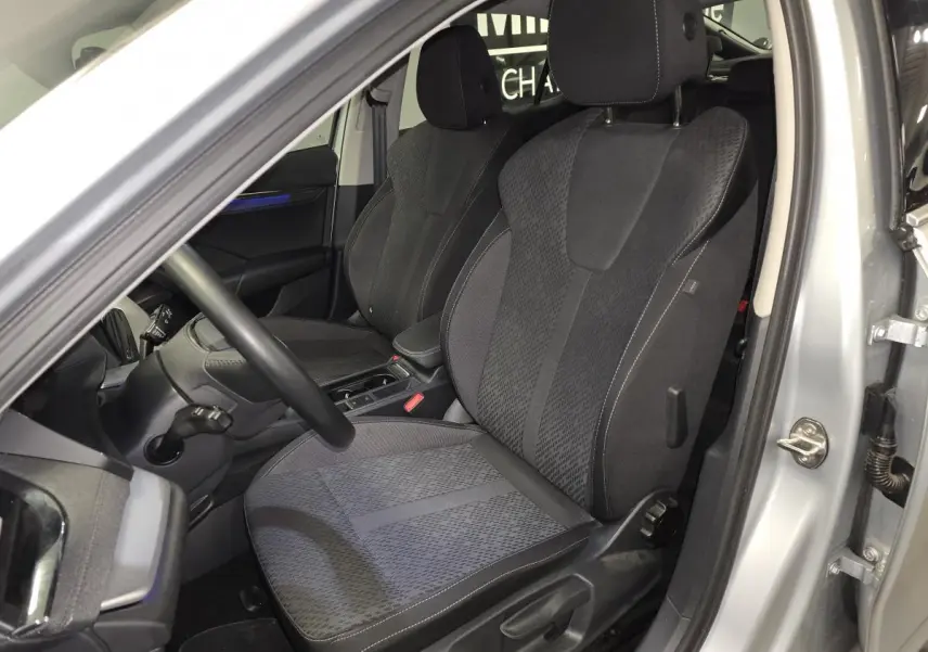 Intérieur avant droit d'une Skoda Octavia 2023 gris, sièges tissu noir avec console centrale visible.